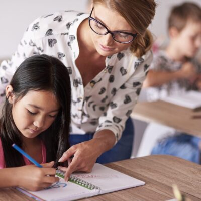 Teacher helping girl in homework